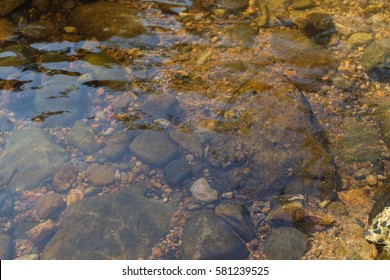 Clear Water In The River Over The Texture Of Rock.