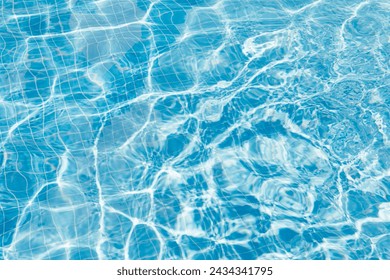 Clear water surface with ripple wave splashes and drops in swimming pool. Abstract turquoise or blue texture water wave and sunlight shadow reflections for background - Powered by Shutterstock