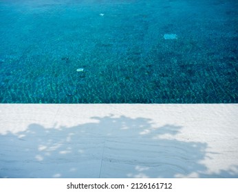 Clear Water Surface With Tree Shadow On Swimming Pool Background, Nobody. Abstract White Marble Tiles Texture Underwater With Grid Tiles Pattern, No People. Summer Background With Copy Space.