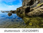 Clear water Tide pool with Rock Formation on Short Sand Beach at Cape Falcon Oregon