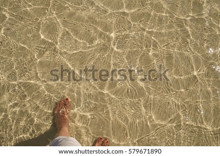 Clear water and woman's feet