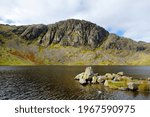 Clear waters of Stickle Tarn lake, located in the Lake District, Cumbria, UK. Popular tourist attractions in Great Langdale valley, famous for its glacial ribbon lakes and rugged mountains.