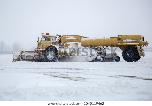 Clearing airport from snow during snow storm.\
clearing runway from snow. Clearing snow with bulldozers from\
airport aprons.