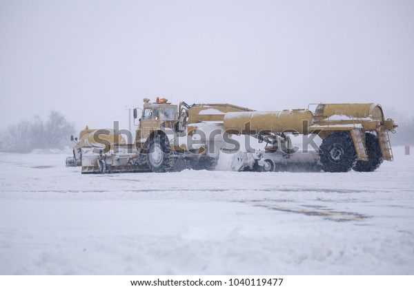 Clearing airport from snow during snow storm.
clearing runway from snow. Clearing snow with bulldozers from
airport aprons.