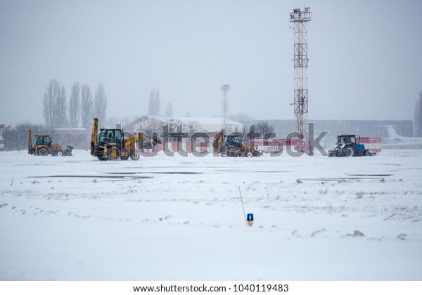 Clearing airport from snow during snow storm.\
clearing runway from snow. Clearing snow with bulldozers from\
airport aprons.