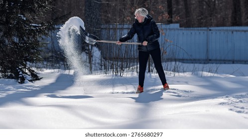 Clearing snow from a path in winter using a shovel.