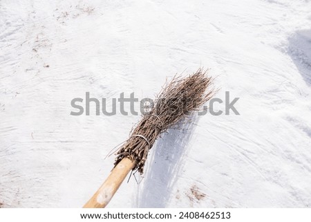 clearing snow from paths with a broom from branches. The way to the house. Cleaning of the territory after a snowfall