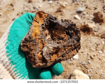 Cleaved sample of limonite iron ore with yellow ocher in hand
