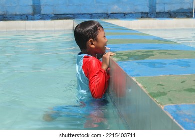 Cleft Lip Boy Holding On To The Edge Of The Pool, Swimming And Playing In The Water