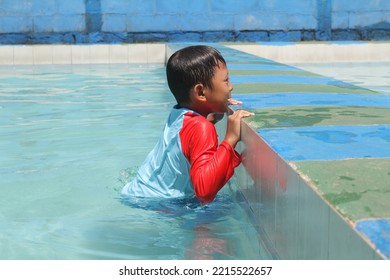 Cleft Lip Boy Holding On To The Edge Of The Pool, Swimming And Playing In The Water