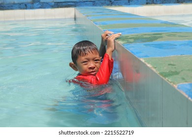 Cleft Lip Boy Holding On To The Edge Of The Pool, Swimming And Playing In The Water