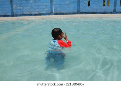 Cleft Lip Child Is Swimming And Playing With Water