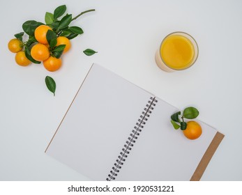 Clementines - Citrus Clementina - Fresh Juice And Sketchpad On White Background. Hybrid Of Small-sized Tangerines. Overhead, Copy Space. 