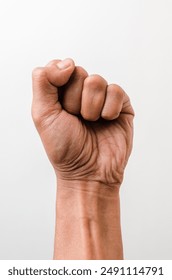 Clenched fist of man's hand isolated on a white background. Asian man's hand skin tone. Clenched fist raised up gesture as a symbol of revolution, movement, rebellion, victory.