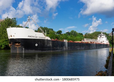 CLEVELAND, OH - August 18, 2020: The Great Lakes bulk carrier American Courage, at over 634 feet in length, slowly navigates the winding Cuyahoga River in Cleveland, Ohio