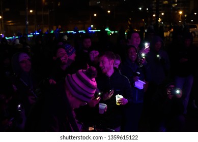 Cleveland, Ohio/USA - February 23 2019: Brite Winter Festival On The Flats Under The Bridge Near Downtown. Crowd Turns On Cell Phone Flash Lights As Requested By Luvabstract.