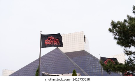 Cleveland, Ohio/USA - June 1, 2019: Image Taken In The Front Of The Rock & Roll Hall Of Fame With Glass Architectural Building Structure And Waving Flags.