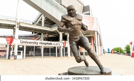 Cleveland, Ohio/USA - June 1, 2019: Large Bronze Cleveland Brown's Hall Of Fame Running Back Jim Brown Statue With American Pro Football Stadium Arena In The Background.