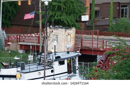 Cleveland, Ohio/USA - June 11, 2019: Large Tug Boat Cruising Down The Cuyahoga River With American Flag Waving In Wind And Sight Of Captain Navigating The Vessel. Top Destination In Cleveland.