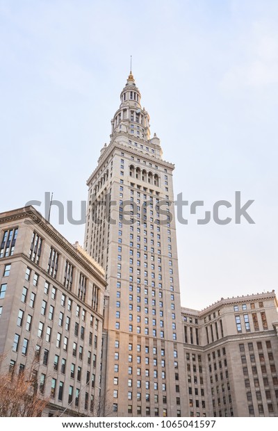 Cleveland, Ohio/USA - March 5th 2018: The Terminal\
Tower with blue sky and golden lighting. The terminal tower is a\
52-story, landmark skyscraper located in Public Square in downtown\
Cleveland Ohio.