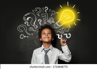 Clever Little Boy On Black Background With Light Bulb. Brainstorming And Idea Concept