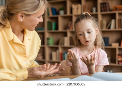 Clever Little Girl Counting On Fingers While Studying With Private Teacher At Home, Female Kid Learning The Numbers And How To Count, Sitting At Desk With Female Tutor