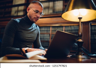 Clever Male Writer Concentrated On Idea For Bestseller Working In Library With Wifi Connection And Book Archive, Young Professor In Spectacles Analyzing Information For Project Making Research