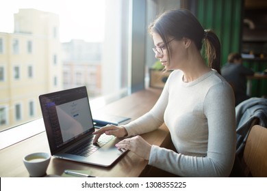 Clever woman skilled blog writer typing promotional article on laptop computer. sitting at desktop in co-working space. Female in spectacles publication specialist using application on notebook  - Shutterstock ID 1308355225