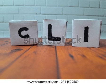 CLI (Command Line) alphabet cube. Black and white with a wooden drawing pad.