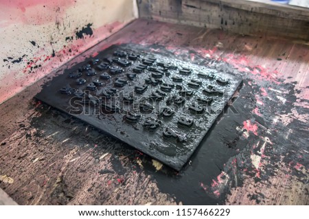 Cliche stamp with text inside an ancient wooden printing press close-up.  History of printing, printing technology. Old printing press letters. Cyrillic alphabet