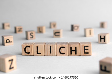 Cliche - word from wooden blocks with letters, very often made and not original and not interesting concept, random letters around, top view on wooden background - Shutterstock ID 1469197580