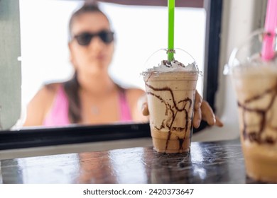 Client buying a iced frappe in a food truck on the beach