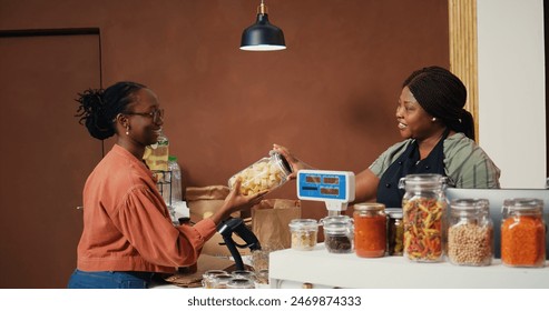 Client buying various pasta and grains in jars from organic shop, supporting local farming business and sustainable lifestyle. Vegan woman looking for chemicals free food essentials. Handheld shot. - Powered by Shutterstock