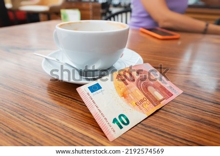 The client left a generous tip after breakfast in the cafe. Ten euro banknote on a table