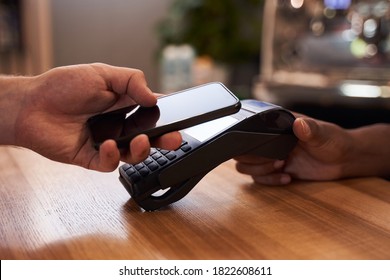 Client paying in cafe with contactless smartphone payment. Business concept - Powered by Shutterstock