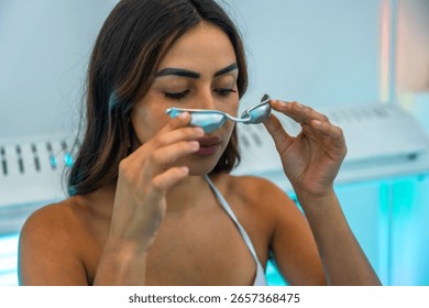 Client preparing for a uv tanning session, holding protective eyewear while getting ready in a beauty salons sunbed area