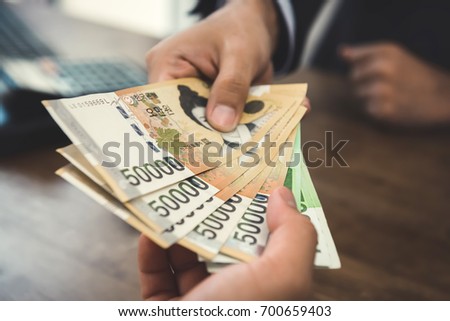 Client receiving money, South Korean Won currency,  from a businessman - buying, payment and bribery concept