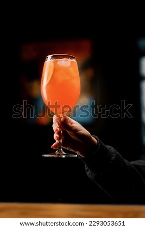 a client of a restaurant bar is holding delicious Aperol spritz cocktail in his hand close-up