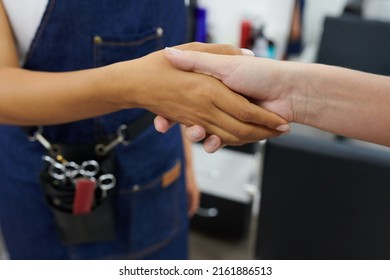 Client shaking hand of hairdresser after getting haircut