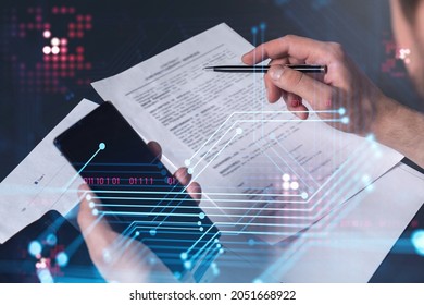 A client is signing the contract to create a software to present it at start up conference and gain investments for innovative service. Checking the details at smartphone. Hologram tech graphs. - Shutterstock ID 2051668922