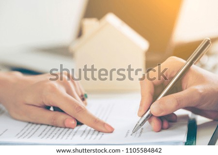 Client signs document regarding real estate activity. Lawyer or real estate agent points at the signature point. Business concept of selling and buying house.