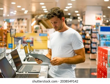 Client With Tablet Choosing Gadgets In Shop