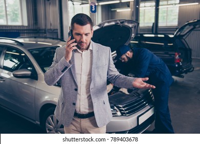 Client Talking On The Smartphone, He Is  Displeased, Complaining About Bad Service, Arguing On Phone, Having Conflict During Telephone Conversation  While Repairman Fixing His Car In Workshop