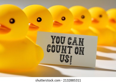 Client Trust And Assurance In Business Concept. Rubber Ducks In A Row Carry A Signboard With The Message You Can Count On Us.