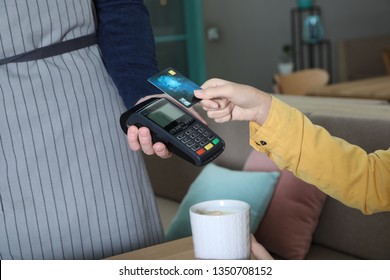 Client using credit card machine for non cash payment in cafe, closeup