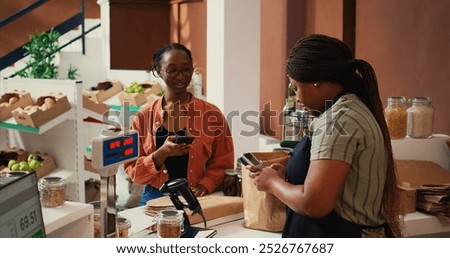 Client using nfc payment at pos to buy eco products, visiting local farmers market to restock pantry essentials. Vegan woman paying with mobile phone at checkout, nonpolluting goods. Handheld shot.