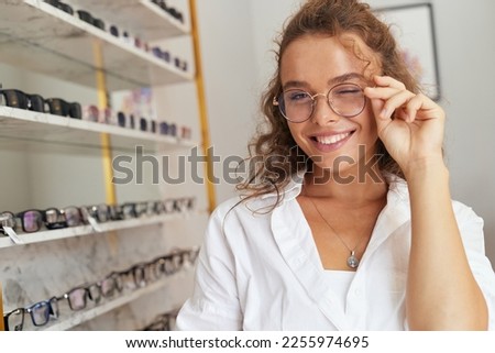 Client Woman At Eyeglasses Store Portrait. Cheerful Female Model In Fashion Eye Glasses With Natural Face Makeup Smiling at Shop. Good Vision Concept