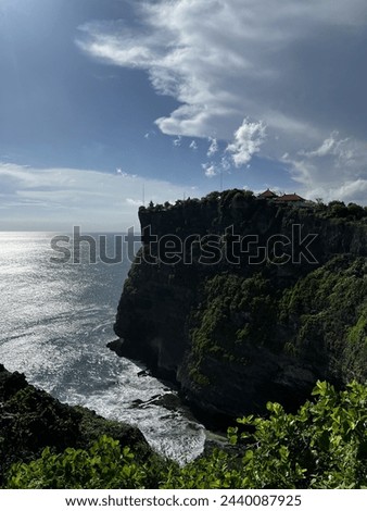 cliff in beach called uluwatu beach, bali with sky blue and clouds, this place is recreation park to watch kecak kecak dance in another side