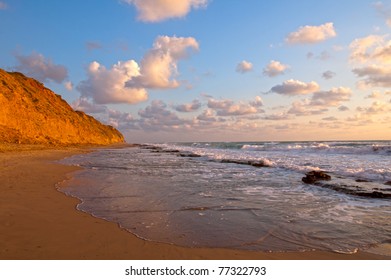 cliff, clouds and surf at sunset
