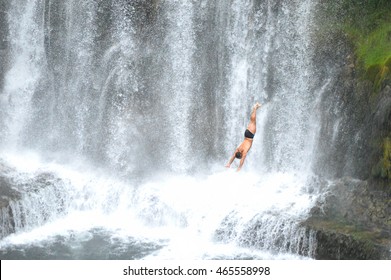 Cliff Diver With Waterfall In Background, Unrecognized And Unknown Man